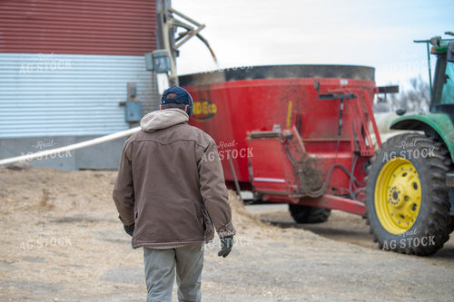 Farmer Walkiing to Feed Wagon 212169
