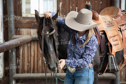 Female Rancher Tacking Horse 117110