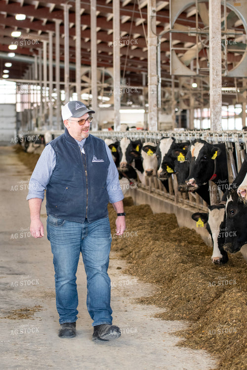 Farmer Walking in Dairy Barn Alley 271011