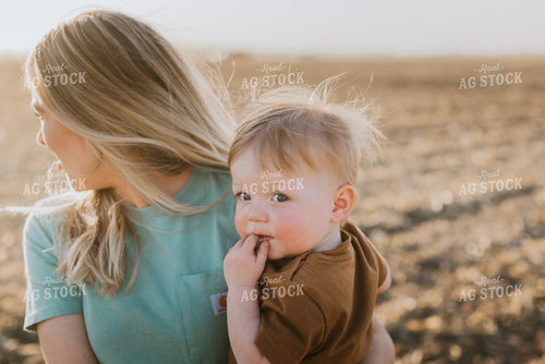 Farm Kid Being Held by Mother in Field 7677
