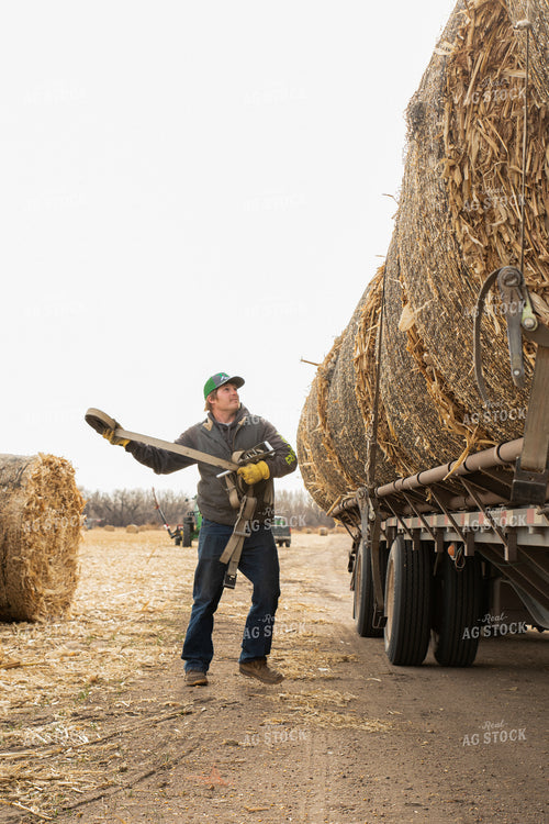 Farmer Secures Bales on Trailer 223011