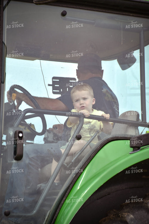 Farmer and Little Boy in Tractor Cab 56429