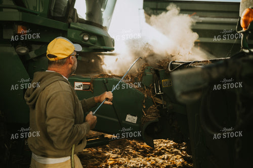 Farmer Cleaning Combine with Air Hose 4663