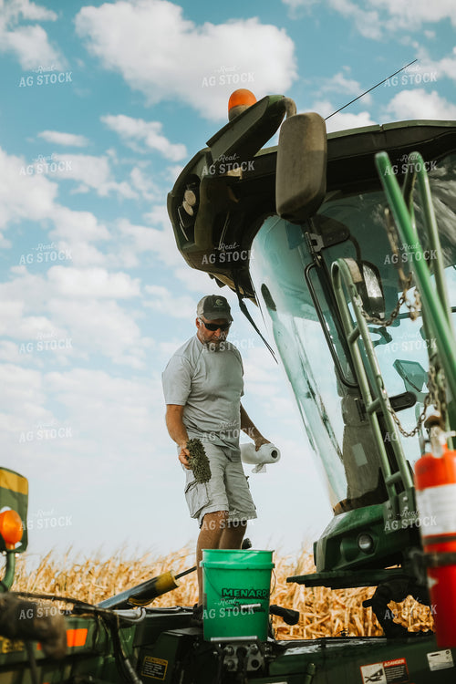 Farmer Working on Combine in Corn Field 5244