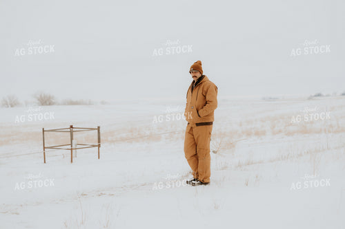 Rancher Standing in Snowy Pasture 61236