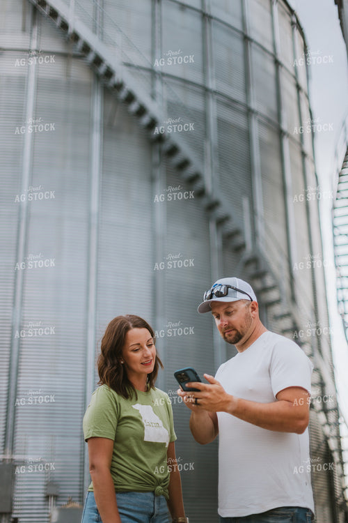 Farmer & Farm Wife Looking at Phone by Grain Bin 8771