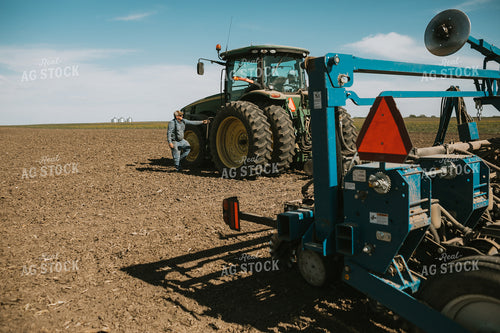 Farmer Climbing into Tractor with Planter 4286