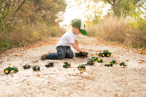 Farm Kid Playing with Toy Tractors 185074