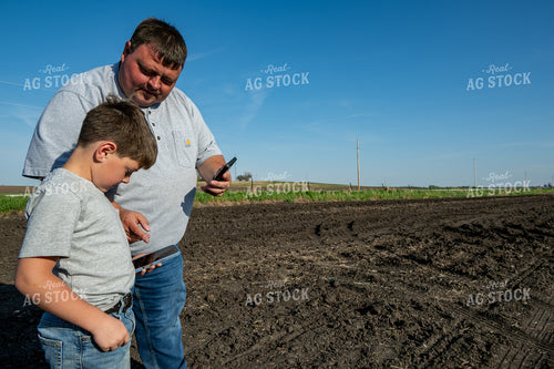 Farmer and Farm Kid Checking Phones in Field 302019