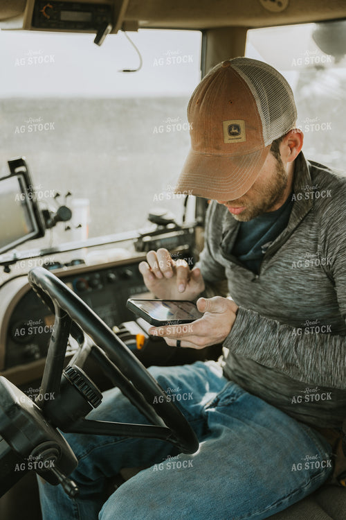 Farmer in Tractor Cab using Phone 8188