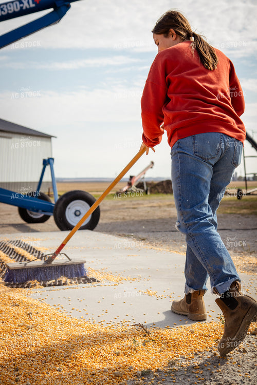 Female Farmer Sweeping Corn into Grain Pit 268111