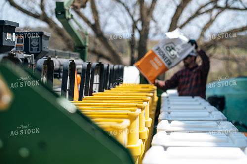 Farmer Filling Planter with Seed Bag 250158
