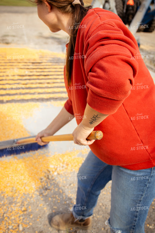Female Farmer Sweeping Corn into Grain Pit 268109