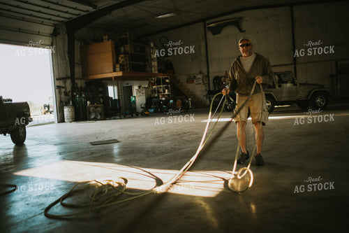 Farmer with Air Hose in Farm Shop 4660