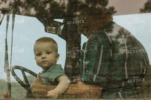 Farm Kid Sits on Grandpa's Lap in Tractor Cab 101037