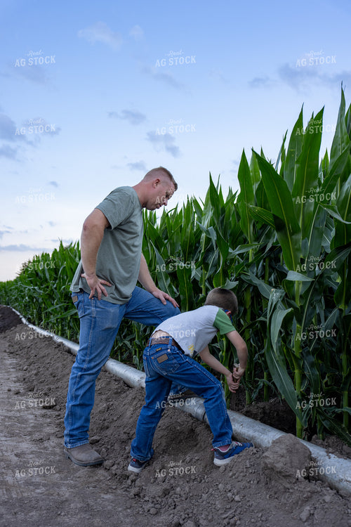 Farmer and Farm Kid Checking Gated Irrigation Pipe 65880