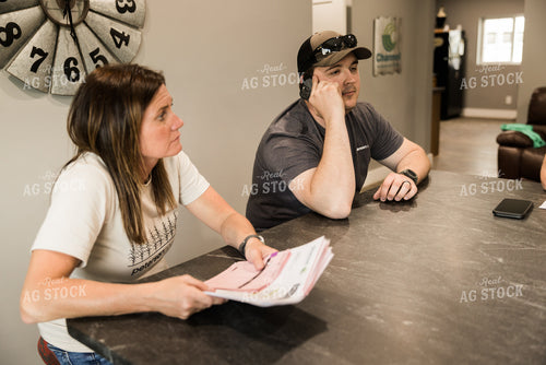 Farmers Review Seed Orders in Farm Office on Phone 7624