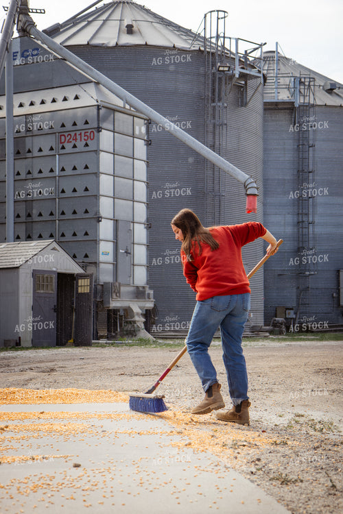 Female Farmer Sweeping Corn into Grain Pit 268105