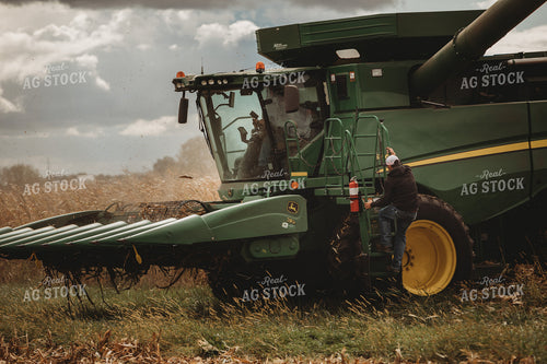 Salesman Climbing into Combine with Farmer 3345