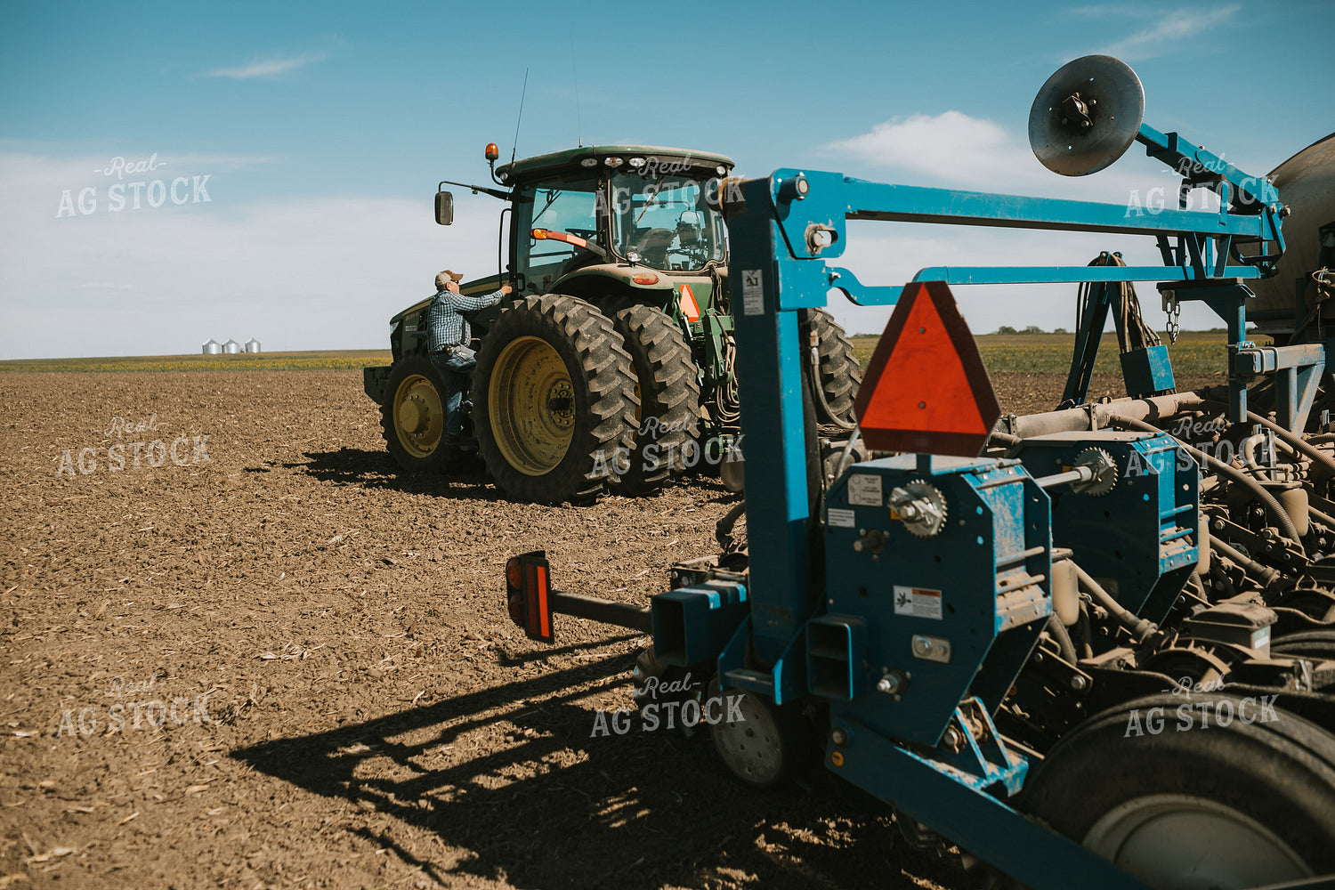 Farmer Climbing into Tractor with Planter 4287