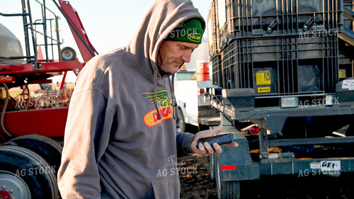 Farmer Talking on Phone with Loading Planter 25187