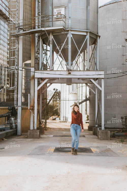 Female Farmer Walking by Grain Bins 8491